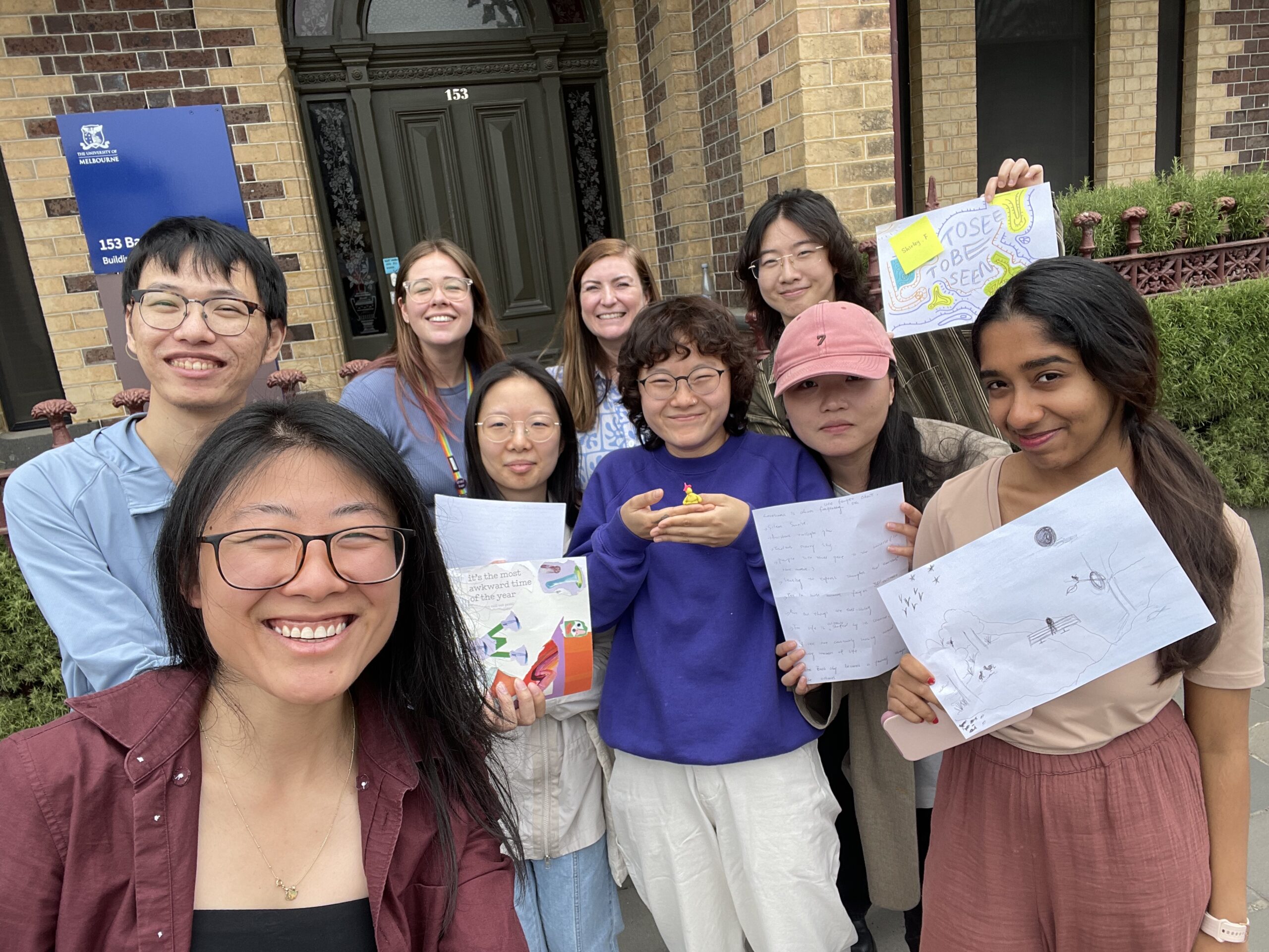 A smiling group of co-designers and the research team. Outside of the ALIVE national Centre building