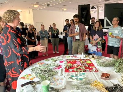 Michelle talking at World Cafe garden table surrounded by group