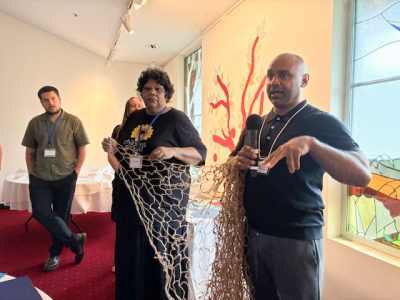 Phil and Veronica holding the net in front of fish table close up